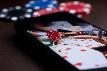 A professional dealer in a tuxedo greeting players at the roulette table, symbolizing the authentic live casino feel at JILI998.