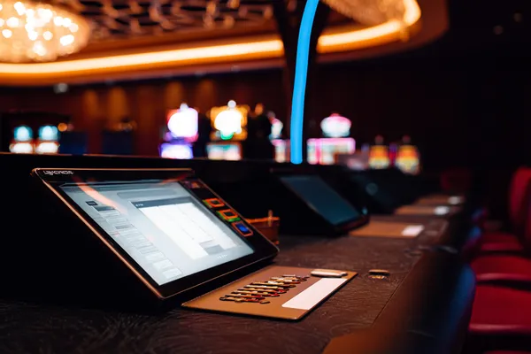 A man celebrating a winning moment on his laptop while gaming symbols float around him, capturing the excitement of JILI998 games.